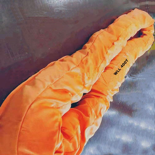 Endless Round Sling, orange sleeved continuous round sling loop with no ends, its working load limit printed on the sleeve, laid out on a steel surface